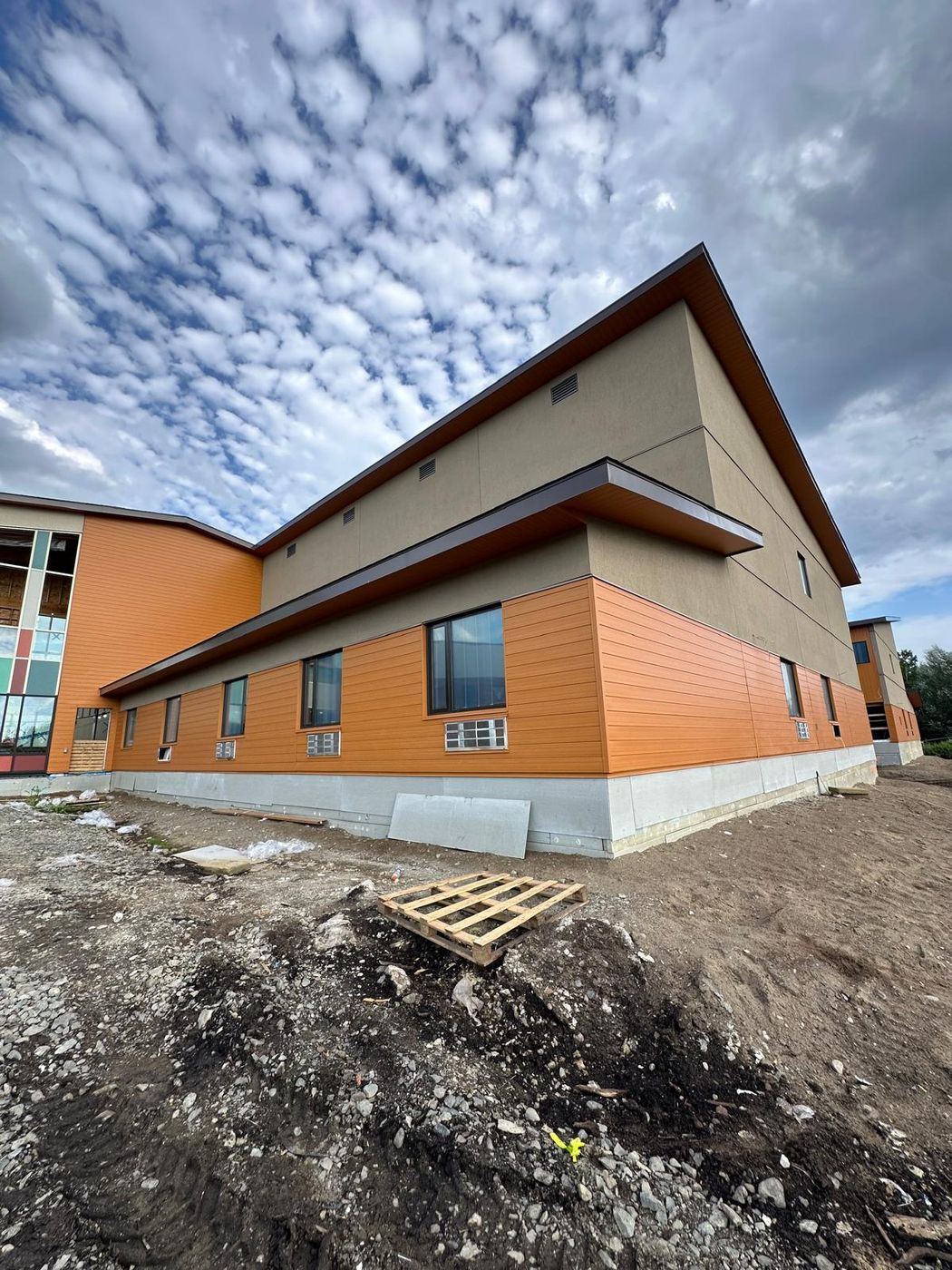 Institutional building with continuous cladding and metal coping